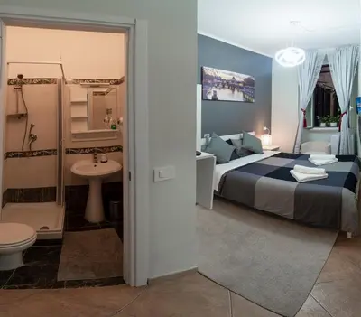 a bedroom with a bed and a bathroom with a sink at Martini Rooms in Rome