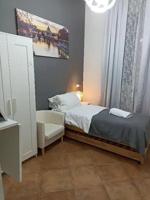 a small bedroom with a bed and a chair at Martini Rooms in Rome