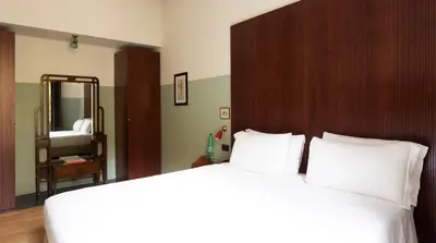 a bedroom with a large white bed and a mirror at Vino e Oli Residenze in Rome