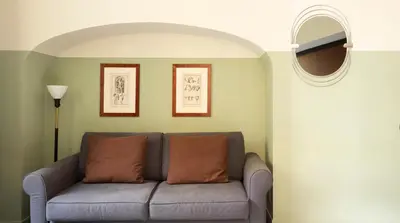 a living room with a couch and a mirror at Vino e Oli Residenze in Rome