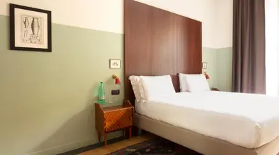 a bedroom with a bed with a wooden headboard at Vino e Oli Residenze in Rome