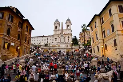 a group of people sitting on stairs in a city at Spagna Historical by Spanish Steps in Rome