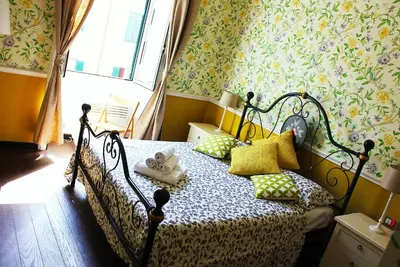 a bedroom with a bed with pillows and floral wallpaper at Casa Fanti 57 in Rome