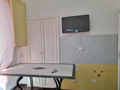 a kitchen with a table and a tv on the wall at Casa Fanti 57 in Rome