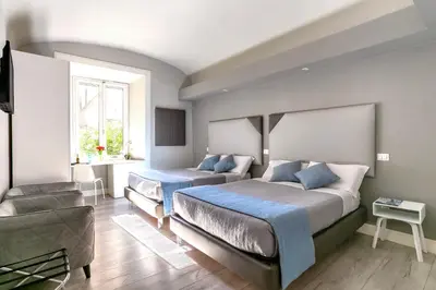 a bedroom with two beds and a couch at Scipioni Best Rooms in Rome