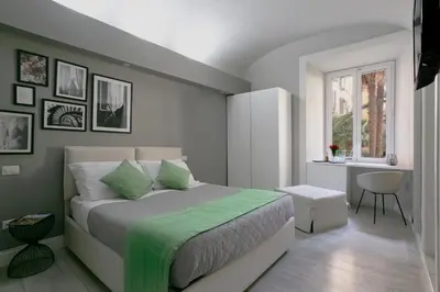 a bedroom with a bed with a green blanket on it at Scipioni Best Rooms in Rome