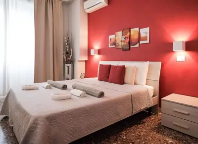 a red bedroom with a bed with towels on it at Roman Holidays House Marconi in Rome