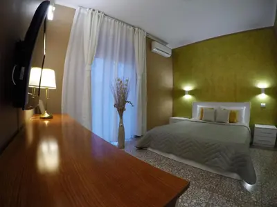 a bedroom with a bed and a vase with flowers in it at Roman Holidays House Marconi in Rome