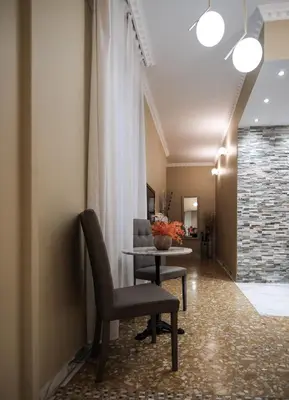a hallway with a chair and a table and a room at Roman Holidays House Marconi in Rome