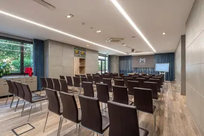 a conference room with chairs and a screen at H10 Roma Città in Rome