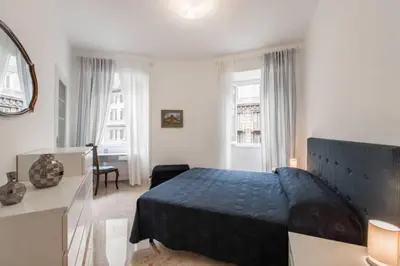 a bedroom with a large bed in a room with windows at EnzHouse in Rome