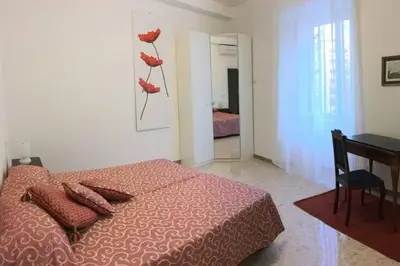 a bedroom with a bed with red pillows and a table at EnzHouse in Rome