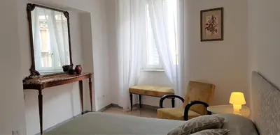 a bedroom with a mirror and a chair and a table at EnzHouse in Rome