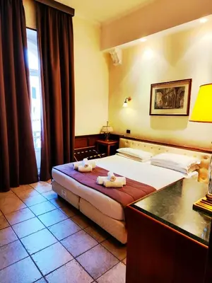 a hotel room with a bed with two towels on it at Hotel Nardizzi Americana in Rome