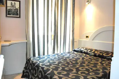 a bedroom with a bed and a large window at Hotel Nardizzi Americana in Rome