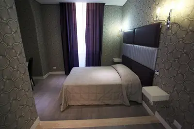 a bedroom with a large bed and a window at Hotel Nardizzi Americana in Rome