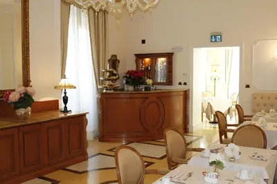 a dining room with tables and chairs and a chandelier at Hotel Villa Pinciana in Rome