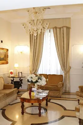 a living room with a couch and a chandelier at Hotel Villa Pinciana in Rome