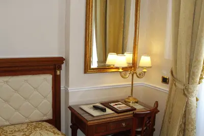 a room with a bed and a table with a lamp at Hotel Villa Pinciana in Rome