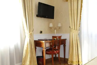 a room with a desk and a television on the wall at Hotel Villa Pinciana in Rome