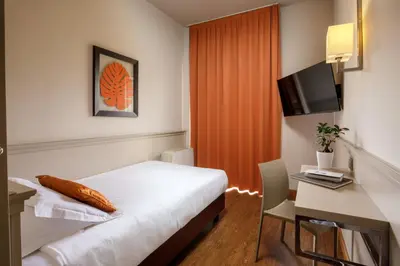 a hotel room with a bed and a desk and a television at Grand Hotel Fleming by OMNIA hotels in Rome