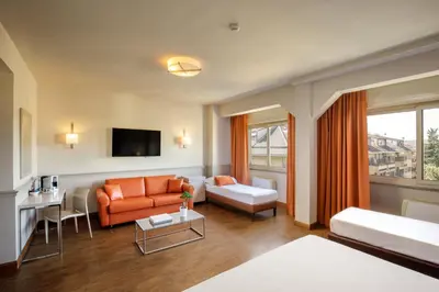 a living room with an orange couch and a table at Grand Hotel Fleming by OMNIA hotels in Rome