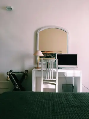 a bedroom with a desk with a computer and a mirror at 4 You City Center Apartament in Rome