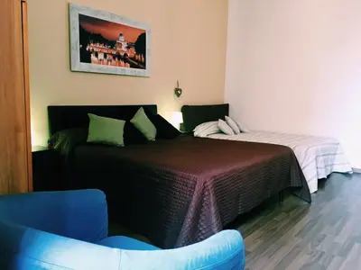 a bedroom with two beds and a blue chair at 4 You City Center Apartament in Rome