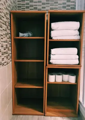a wooden book shelf with white towels in a bathroom at 4 You City Center Apartament in Rome