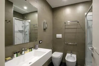 a bathroom with a sink and a toilet and a mirror at Stay Inn Rome Via Del Corso in Rome