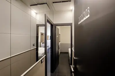 a hallway of a bathroom with a sign on the wall at Stay Inn Rome Via Del Corso in Rome