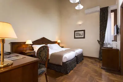 a hotel room with a bed and a desk at Hotel Teatro Pace in Rome