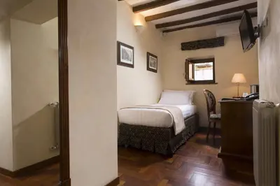 a bedroom with a bed and a chair in a room at Hotel Teatro Pace in Rome