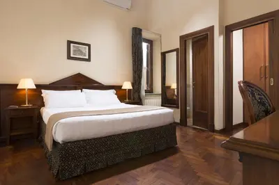a hotel room with a large bed and a desk at Hotel Teatro Pace in Rome