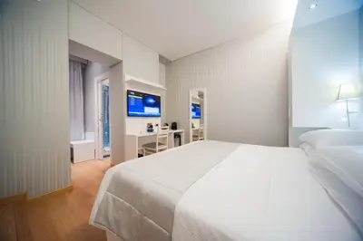 a bedroom with a large white bed and a desk at Trevi 41 Hotel in Rome