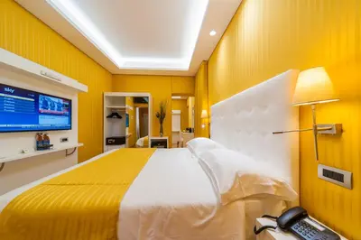 a bedroom with a large bed with a yellow wall at Trevi 41 Hotel in Rome