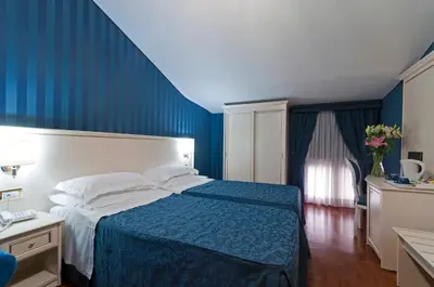a hotel room with a bed and a blue wall at Trevi 41 Hotel in Rome