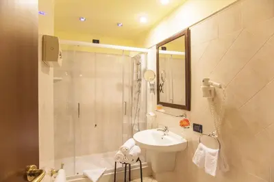 a bathroom with a shower and a toilet and a sink at Hotel Tuscolana in Rome
