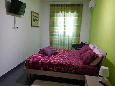 a bedroom with a bed with purple sheets and a window at Studiohouserome in Rome