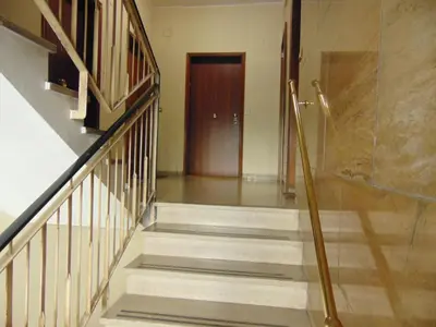 a hallway with stairs and a wooden door at Studiohouserome in Rome