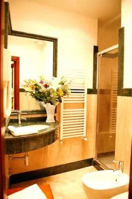 a bathroom with a sink and a vase of flowers at Luxury Ludovisi Rooms in Rome