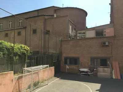 an empty parking lot in front of a brick building at Caracalla Room Rental in Rome