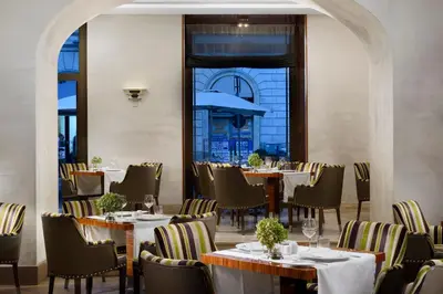 a restaurant with tables and chairs and a large window at UNA Hotels Decò Roma in Rome