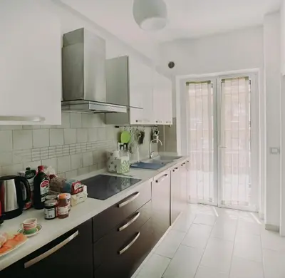 a kitchen with white cabinets and a large window at Casanova in Rome
