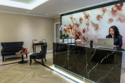 a woman sitting at a reception desk with a laptop at The Boutique Hotel in Rome