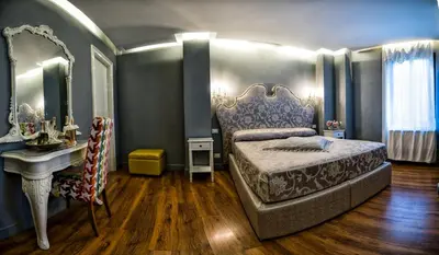 a bedroom with a bed and a sink and a mirror at Hotel Antica Locanda in Rome