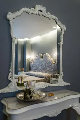 a mirror over a table in a room with a bed at Hotel Antica Locanda in Rome