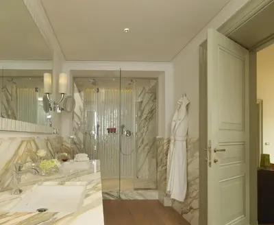 a bathroom with a shower and a sink and a mirror at Rocco Forte Hotel De Russie in Rome