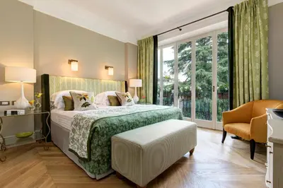 a bedroom with a bed and a large window at Rocco Forte Hotel De Russie in Rome