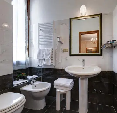 a bathroom with a sink and a toilet and a mirror at Hotel Residenza In Farnese in Rome